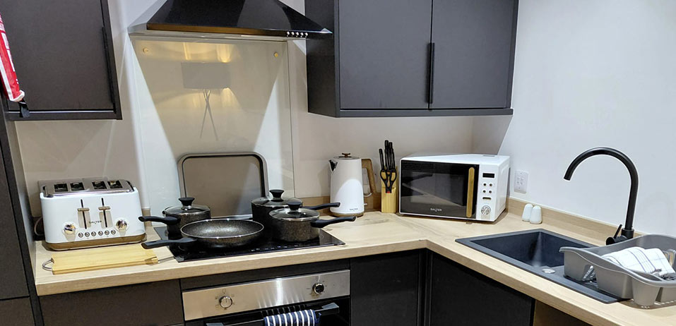Fitted kitchen with black cabinetry and appliances