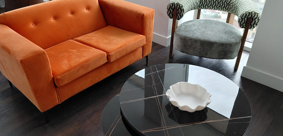 Statement orange sofa and marble coffee table in a styled living space
