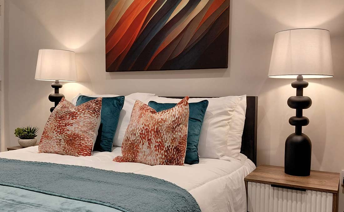 Bedroom styled with statement artwork and coordinated cushions