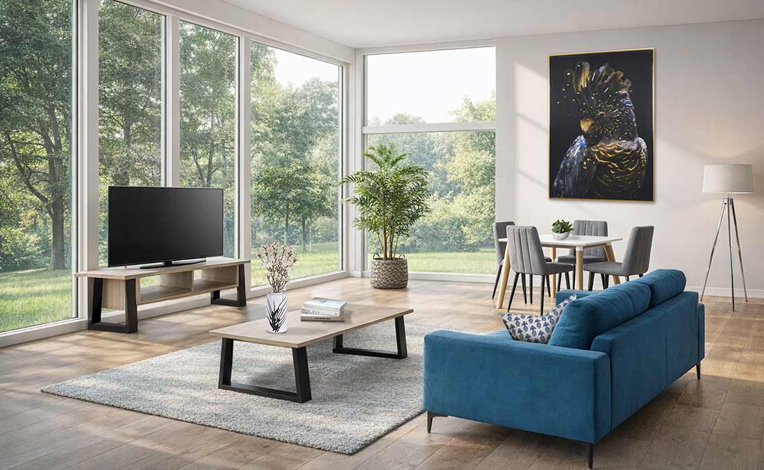 Bright open-plan living and dining space with blue sofa and statement artwork