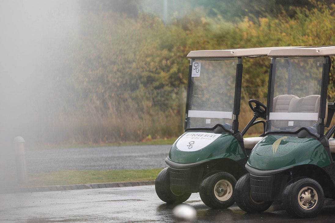 A Stroke Play Golf branded buggy parked beside a Longhirst buggy on a wet morning
