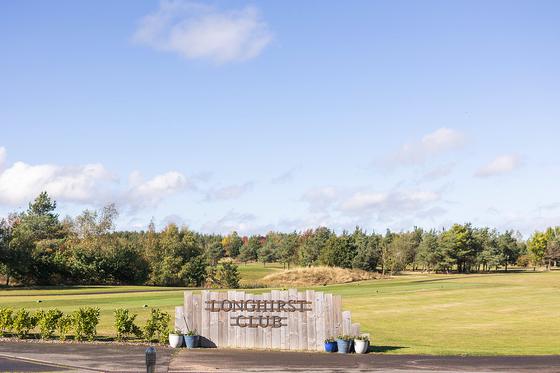 The Longhirst Club sign beside the fairway on a bright autumn day