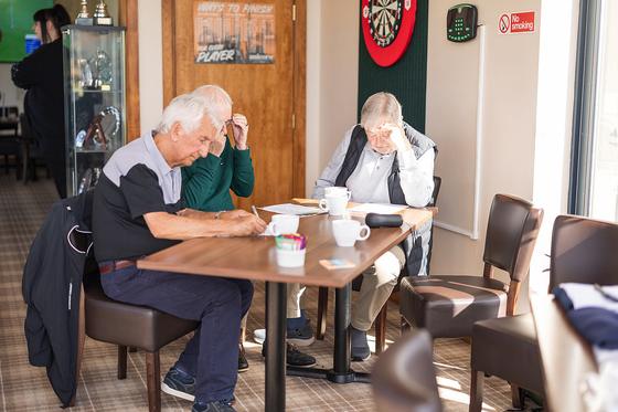 Three guests enjoying a cup of tea and a puzzle